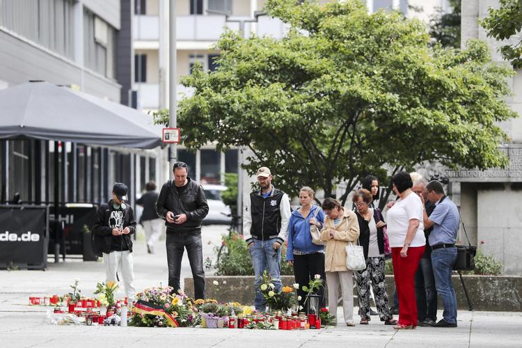 Blomster er efterladt på det sted, hvor en 35-årig tysk mand blev knivdræbt under en byfest lørdag nat - angiveligt af to asylansøgere fra Irak og Syrien. Jan Woitas/AP