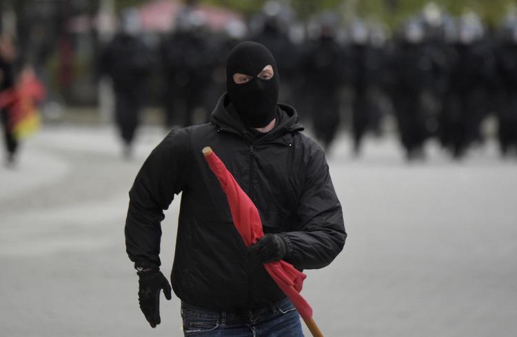 uro.  En maskeret demonstrant lørdag aften i Chemnitz. Stort politiopbud betød,  at der ikke kom sammenstød.  Jens Meyer/AP