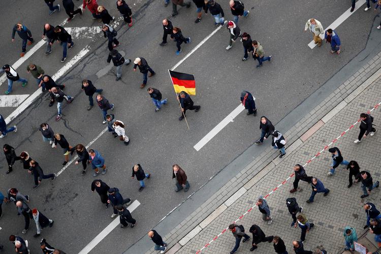 Højreorienterede  demonstranter går i sørgemarch for den myrdede Daniel H. med det tyske flag. I går efterlyste politiet en tredje  asylansøger for medvirken til mordet.  Arkivfoto: Hannibal Hanschke/Reuters Arkivfoto Hannibal Hanschke/Reuters