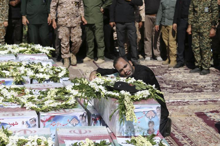 Faderen til 4-årige Mohammad Taha Eghadami sørger her ved drengens kiste. Drengen blev dræbt ved angrebet lørdag. I går var der  begravelse af ofrene ved en ceremoni  i Sarallah-moskeen i Ahvaz. Ebrahim Noroozi/AP