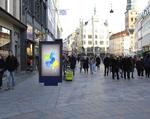 Sådan vil den nye reklamestander ifølge kommunen komme til at tage sig ud på kunstneren Bjørn Nørgaards granitbelægning ved en af Strøgets fineste adresser på Amagertorv i København. Kollage:  Dennis Bressendorf (foto) og Københavns Kommune 