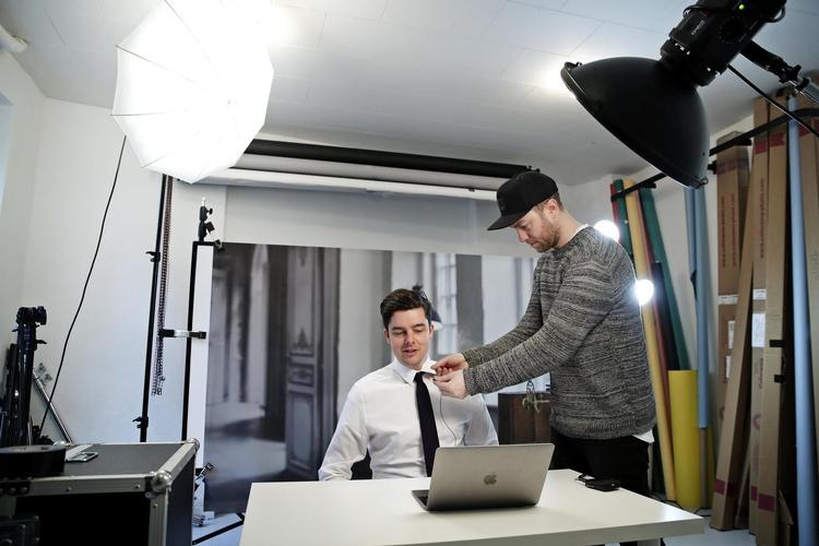 Andreas Martin er ved at sætte en mikrofon på Michael Schøt i det lille studie, hvor et billede af Michael Schøts gamle lejlighed lyver rummet større, når det bliver fanget i kameraet. De skal til at optage ugens tale til Schøtministeriet. 