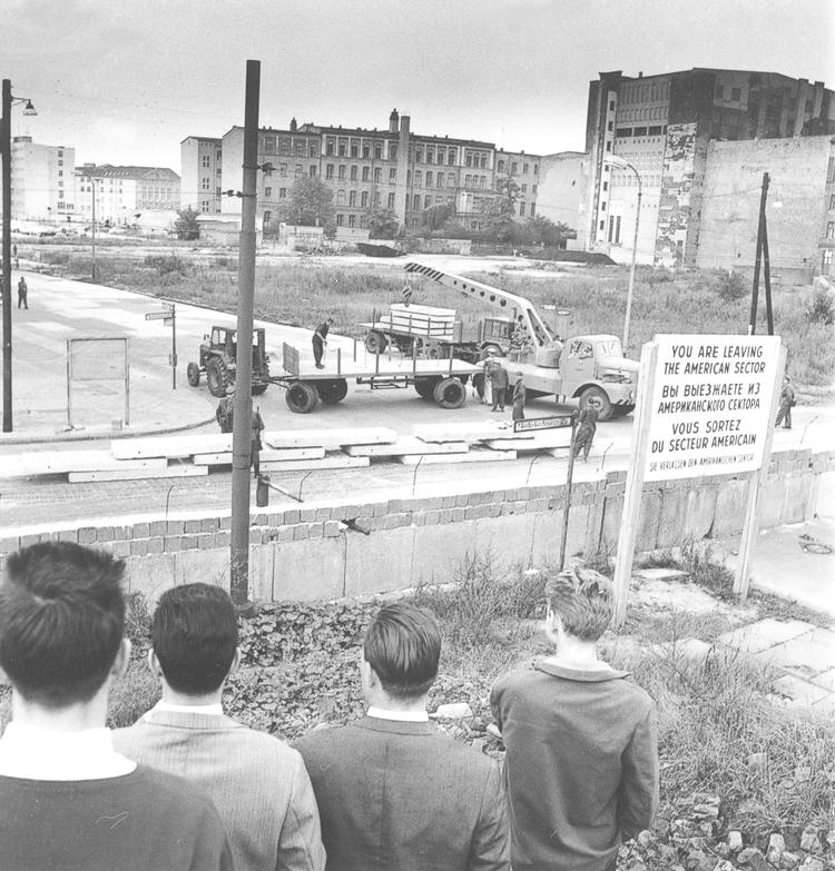 Forundrede drenge i Vestberlin kigger på, mens øst-tyskere forstærker Muren i september 1961. Få måneder senere gav DDR’s minister for statens sikkerhed, Erich Mielke, ordre til, at Stasi-agenter skulle finde de kunst-skatte, der lå gemt i private bank-bokse i hele DDR. 