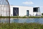 Et blik over mod den kunstige museumsø med Arkens mure – og Nanna Debois Buhls store foto af en skrøbelig insektvinge. 