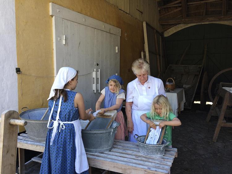 Takket være en hel flok frivillige lykkes det Amagermusset at levendegøre historien - som her hvor tre små piger får lov til at lege vaskekoner for en stund.  