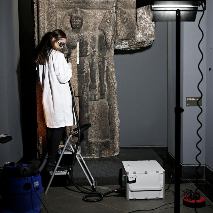 Stor granitskulptur, der er blevet sortsmudset af forurening. Den stod udendør tidligere. Nu har de fundet ud af, at den kan laserrenses. der er stor forskel på farven og de er i gang lige nu. 
Her er konservator in action med laserrenser. 