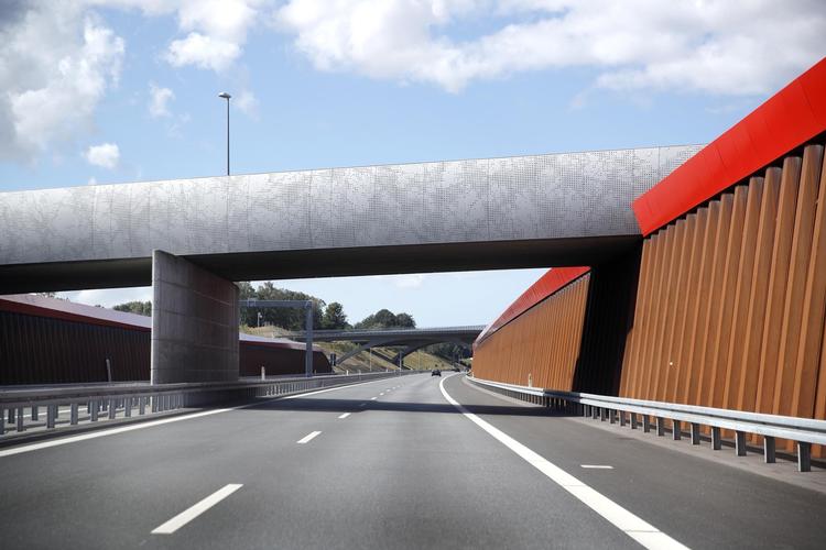 Flere af broerne over motorvejen er forsynet med hvide rækværk. Når det er mørkt, lyser de i et fint kniplingemønster. I løbet af 10 sekunder suser man under fem af slagsen lige efter hinanden. Det er mageløst. 