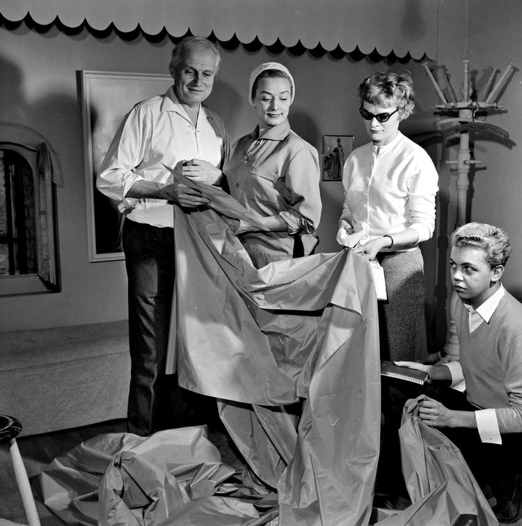 Holger Blom elskede teatret og syede kostumer til det meste af København. Her prøver Lily Broberg i 1959. Fru Gerda (med briller) var Bloms højre hånd, og knælende ses en ung Jørgen Bender. Både han og Erik Mortensen slog deres første kjolefolder hos Blom. 