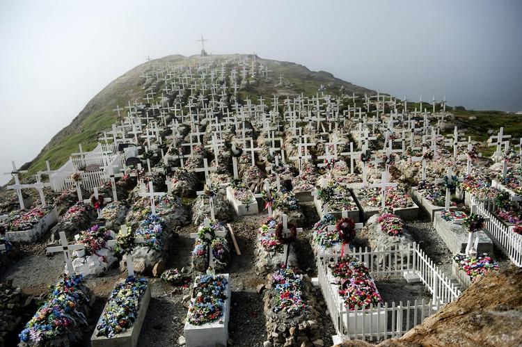 Grønland. I Uppernavik nord for polarcirklen ligger kirkegårdene på bygdernes bedste grunde så højt som muligt, så de døde sælfangere og jægere kan skue ud over deres tidligere jagtmarker ude på havet. På grund af permafrosten er jorden det meste af året så hård, at det  er umuligt at grave i den. Derfor stiller grønlænderne kisterne oven på jorden og klapper cement og sten op omkring dem. Kisterne bliver i forbindelse med begravelsen dekorerer med plastikblomster og kors.  