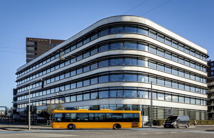 100 år efter den moderne stil fandt sin form med horisontale vinduesbånd i lette ikke-bærende facader, kan den stadig tage sig frisk ud som her med rundt afskårne hjørner, der synes formet efter trafikken. 