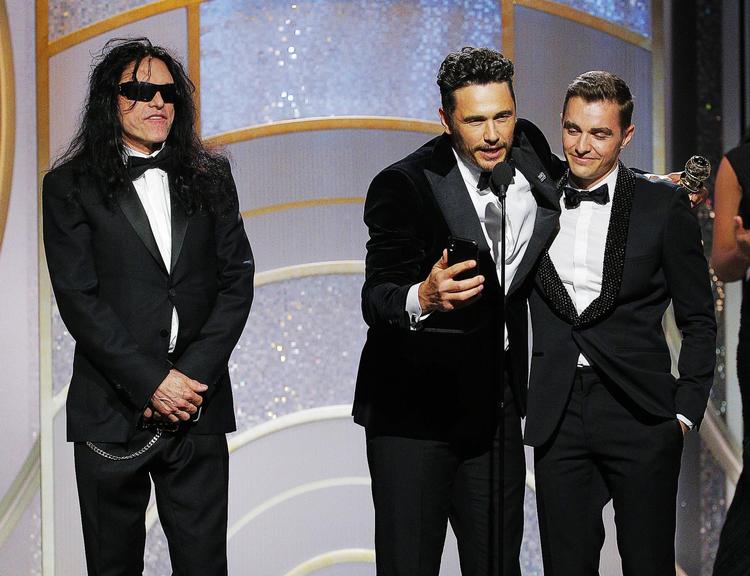 Virkelighedens Tommy Wiseau (tv.) var med på scenen, da James Franco i januar modtog en Golden Globe for sin rolle som Wiseau i ’The Disaster Artist’. Til højre Francos lillebror, Dave, som i filmen spiller Wiseaus ven Greg Sestero. Foto: AP 
