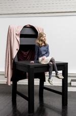 Peter Holst Henkels værk ’Voksenhed forklaret for børn’ fra 2018 er en gigantisk stol med en lige så gigantisk jakke hængende over stoleryggen. På jakken er printet fotos af hænder, som enten beskytter eller afstraffer. Anders Sune Berg