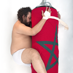 Performancekunstneren Youssef Ouchra i en intim omfavnelse af en boksebold. Foto Youssef Ouchra