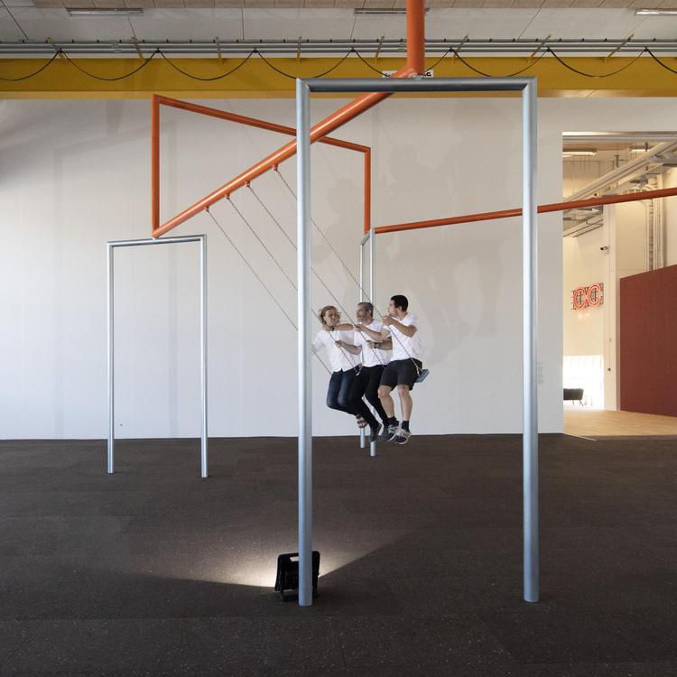 Superflex' gyngeinstallation passer perfekt til Copenhagen Contemporarys sale, hvor stativernes rette linjer korresponderer med loftets industrielle rørføringer og gule farve. Anders Sune Berg