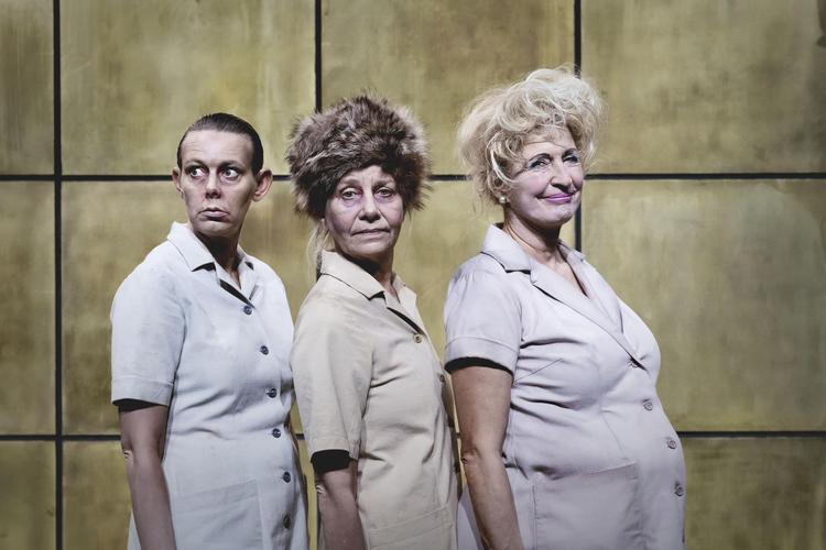 På en baggrund af bæbrune fliser kredser Stine Schrøder Jensen, Kirsten Olesen og Karen-Lise Mynster rundt i deres fesne kitler som kældermennesker på samfundets bund. Camilla Winther