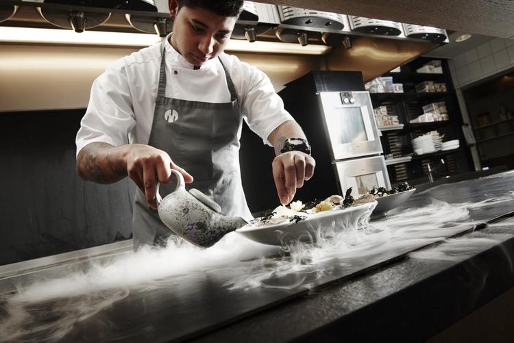 Bryan Francisco på Treetop i Vejle er i færd med at anrette en ret med østerstartar, kammuslinger og belugakaviar. Røgen stammer fra tøris.  