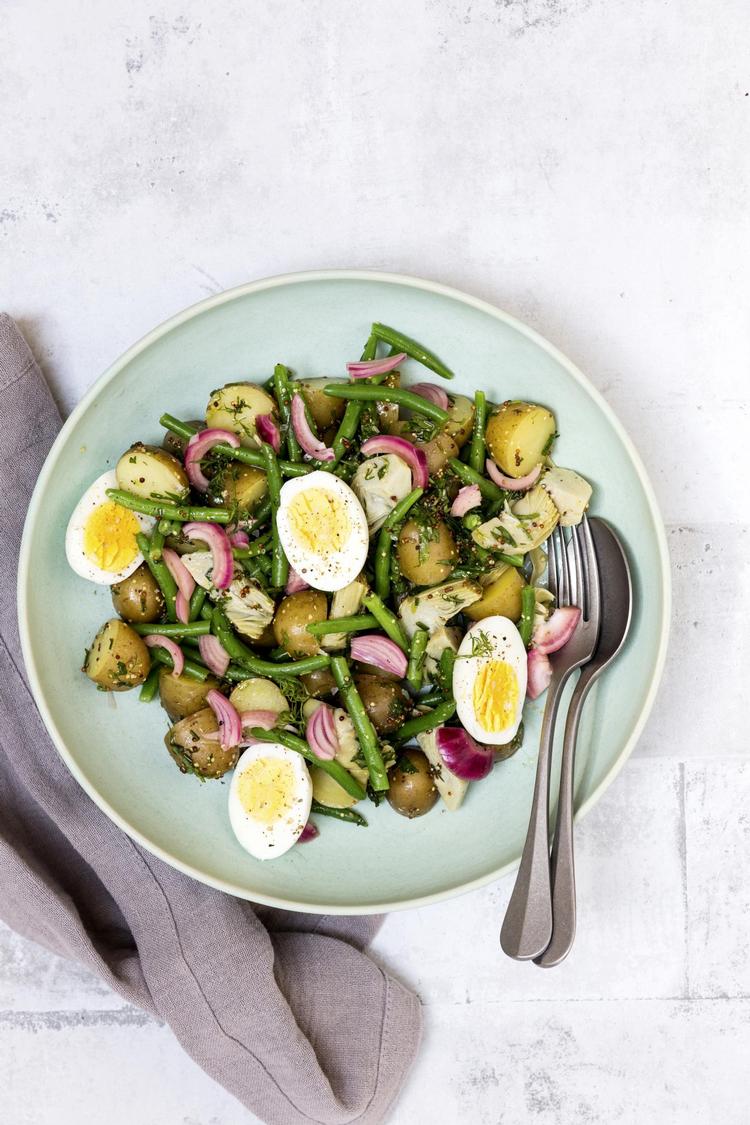 Med kartofler, grønne bønner og kogte æg er der gods i denne salat. Masser af krydderurter og syltede rødløg giver både smag og smukt farvespil. 