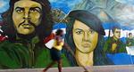 En kvinde passerer billedet af Cubas revolutionære helt Ernesto "Che" Guevara i Havana. 