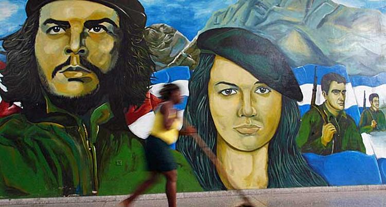 En kvinde passerer billedet af Cubas revolutionære helt Ernesto "Che" Guevara i Havana. 