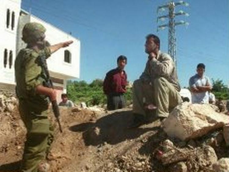 En israelsk soldat afviser nogle palæstinensere ved en vejspærring udenfor Hebron på den sydlige Vestbred. Foto: AP 