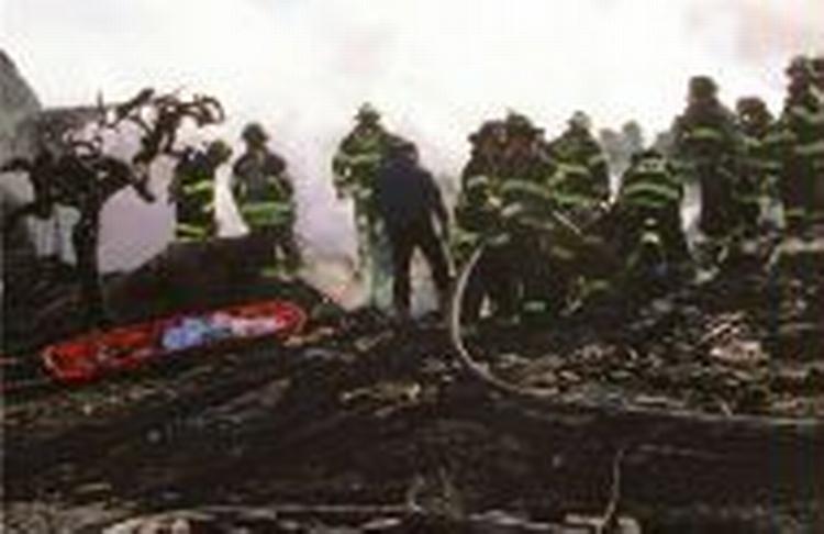 Brandfolk og redningsarbejdere rydder op efter flystyret i Queens, New York, mandag. - Foto: AP 