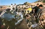 Palæstinenensere undersøger vraget af den bil, hvori Mahmoud Abu Hanoud blev dræbt nær Nablus. - Foto: AP 