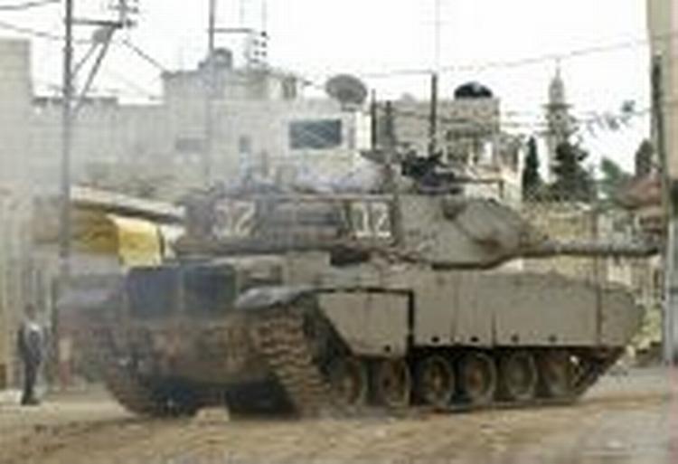 En israelsk tank i byen Betonia på Vestbredden mandag. Arafat klandrer Israel for at kun at ville en militær løsning på konflikten. - Foto: AP 