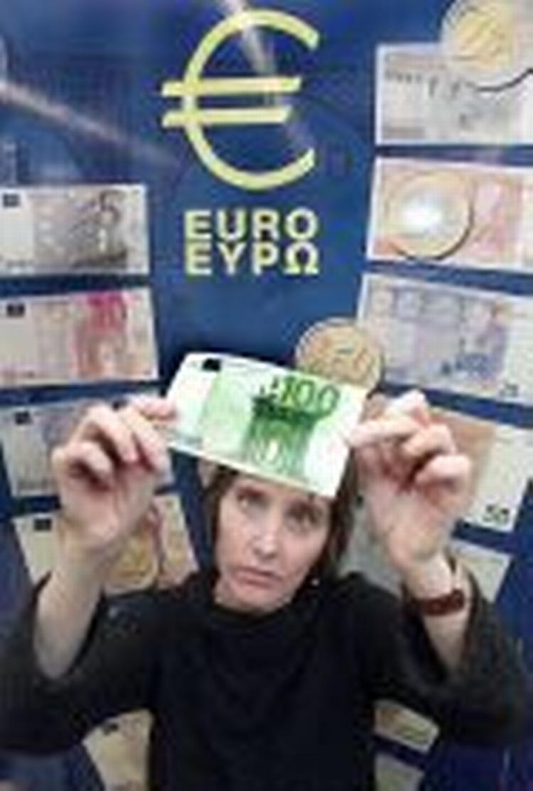 En spansk kvinde undersøger en af de nye 100 euro-sedler i en afdeling af Caja Navarra-banken i den nordspanske by Pamplona. - Foto: AP 