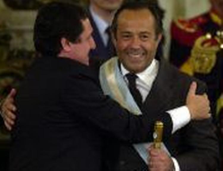 Den nyudnævnte præsident omfavnes af Senatets leder, Puerta, under indsættelsesceremonien søndag. - Foto: AP 