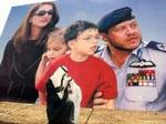 To jordanske mænd foran en kæmpeplakat med landets kongefamilie. - Foto: AP 