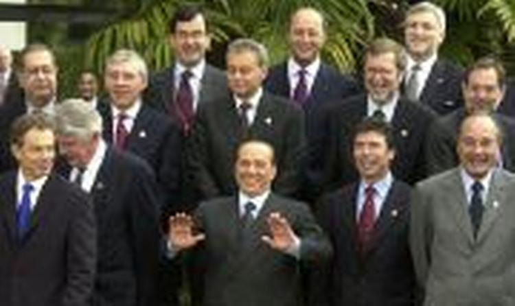 Familefotoet fra topmødet. Fogh Rasmussen har stillet sig mellem Berlusconi og Chirac - og foran Per Stig Møller, som dog godt kan ses. - Foto: AP. 