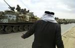 En ældre palæstinenser parlamenterer med israelske soldater i Ramallah på Vestbredden, hvor der fortsat mandag er kampe omkring Arafats hovedkvarter. - Foto: AP 