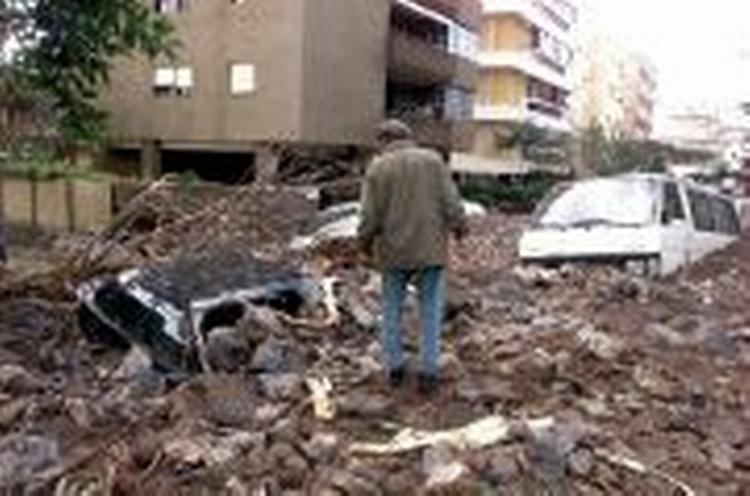 Gadebilledet i Santa Cruz efter søndagens uvejr. Bilerne er begravet under mudder og sten. - Foto: AP 