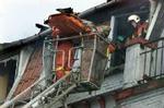 En af de fire omkomne bæres ud af bygningen søndag formiddag. - Foto: AP 