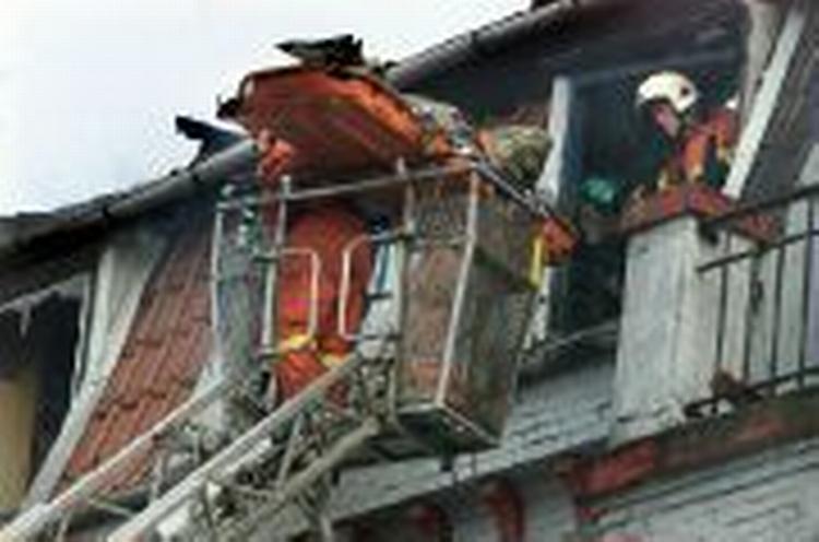 En af de fire omkomne bæres ud af bygningen søndag formiddag. - Foto: AP 