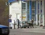 Røverne og et gidsel forlader bilen for at tanke op i Ukraine. - Foto: AP 