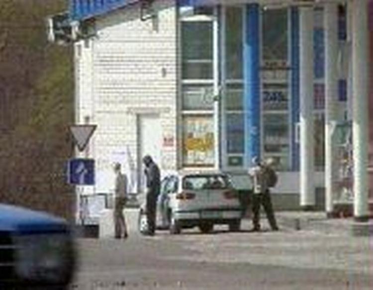 Røverne og et gidsel forlader bilen for at tanke op i Ukraine. - Foto: AP 