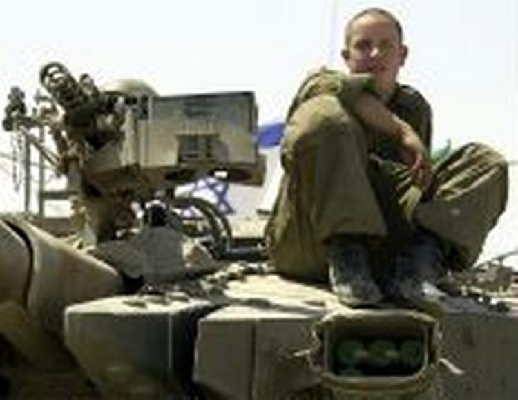 En israelsk soldat sidder på en kampvogn uden for Betlehem. Kampvognen er på vej til at blive sat om bord på en lastbil og kørt væk fra området. - Foto: AP 