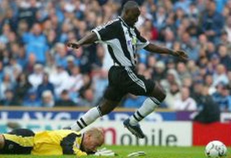 Newcastles Lomana Lualua på vej hen over Manchester Citys Peter Schmeichel. - Foto: AP 