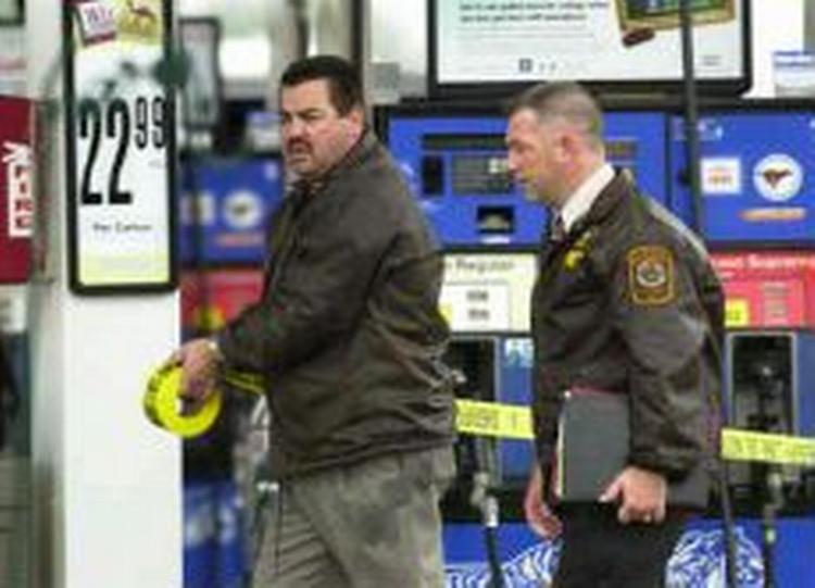 Virginia politifolk ruller tape ud på gerningsstedet, en Exxon benzinstation, hvor en mand fredag morgen lokal tid blev dræbt, muligvis af en mystisk snigskytte. - Foto: AP 