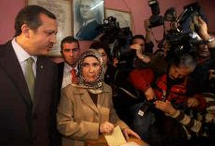 Recep Tayyip Erdogan, den folkeligt populære leder af partiet Retfærd og Udvikling, kan pga. en gammel dom ikke blive ny leder i Tyrkiet. Her stemmer han i selskab med sin hustru. - Foto: AP 