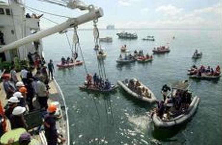 Filippinske redningsfolk leder efter overlevende i Manila-bugten mandag morgen. - Foto: AP 