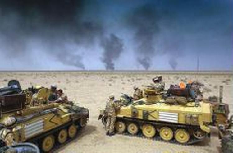 Britiske soldater betragter røg fra brændende oliekilder i det sydlige Irak. De fleste af kilderne er på koalitionens hænder, siger briterne og amerikanerne. - Foto: AP 