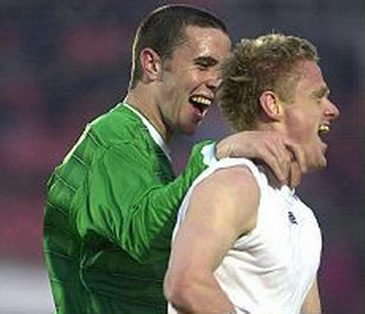 Blackburns Damien Duff har smidt trøjen efter sin scoring mod Georgien. Manchester Uniteds John O'Shea siger tillykke. - Foto: AP 
