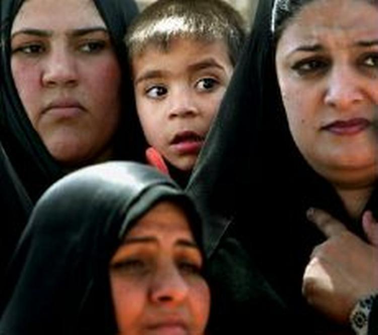 En lille dreng venter i kø sammen med en gruppe irakiske kvinder. - Foto: AP 