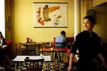 Atmosfæren i Lê Lê nhà hàng er som i en neoklassisk parisercafé, med umage borde og stole, højt til loftet og hurtig, venlig betjening. Her er Lam Le Hoang på vej igennem restauranten. - Foto: Miriam Dalsgaard. 