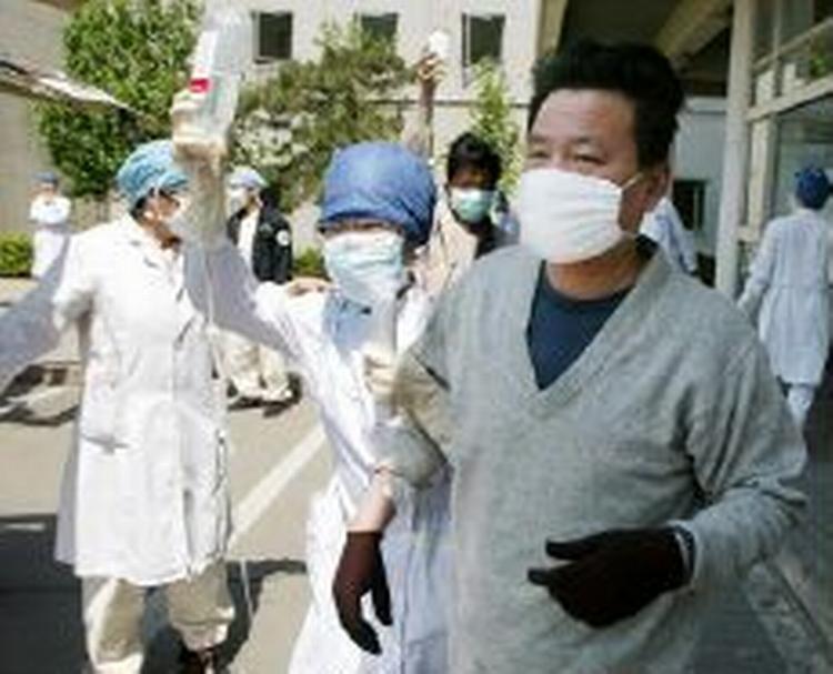 En patient flyttes fra det japansk-kinesiske sygehus i Beijing. Alle ikke-SARS-patienter flyttes til andre sygehuse i den kinesiske hovedstad. - Foto: AP 
