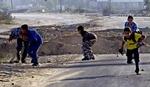 Palæstinensiske børn hører en israelsk kampvogn nærme sig og går i dækning. - Foto: AP 