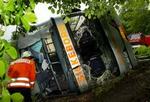 Redningsfolk undersøger den væltede bus. - Foto: AP 