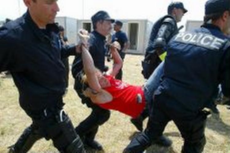 Politiet bærer en demonstrant væk på en campingplads. - Foto: AP 